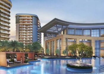 Luxurious clubhouse and swimming pool at Rishita Serenity at dusk.